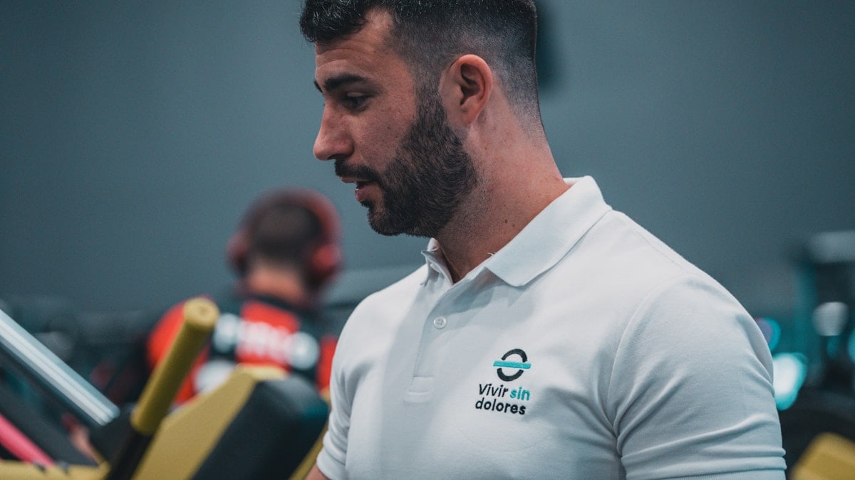 Sesión de entrenamiento en el gimnasio con un entrenador personal, enfocada en el rendimiento y el bienestar físico.
